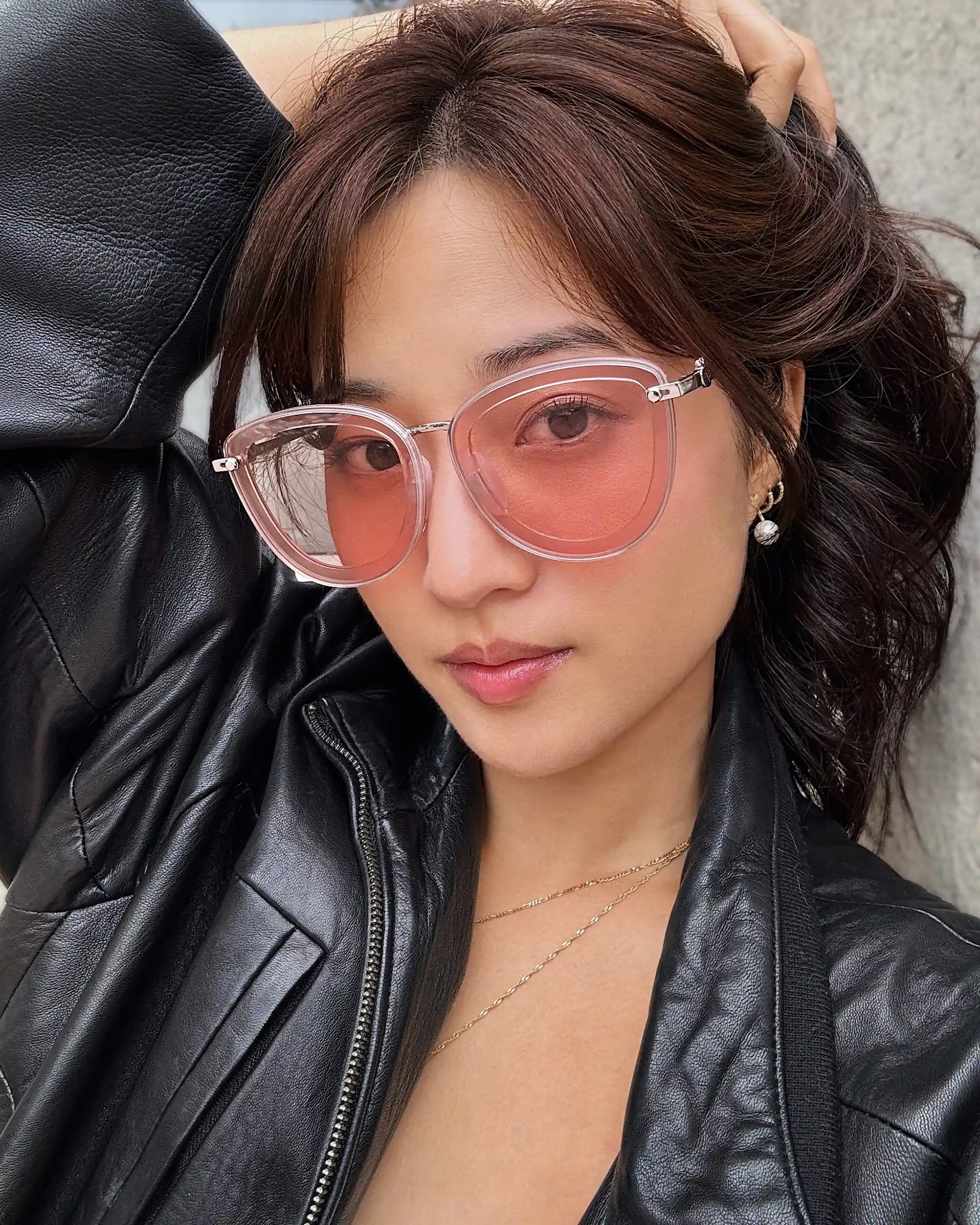 Woman wearing Sweet Pain JULIA R1 sunglasses in rosé, leather jacket street style