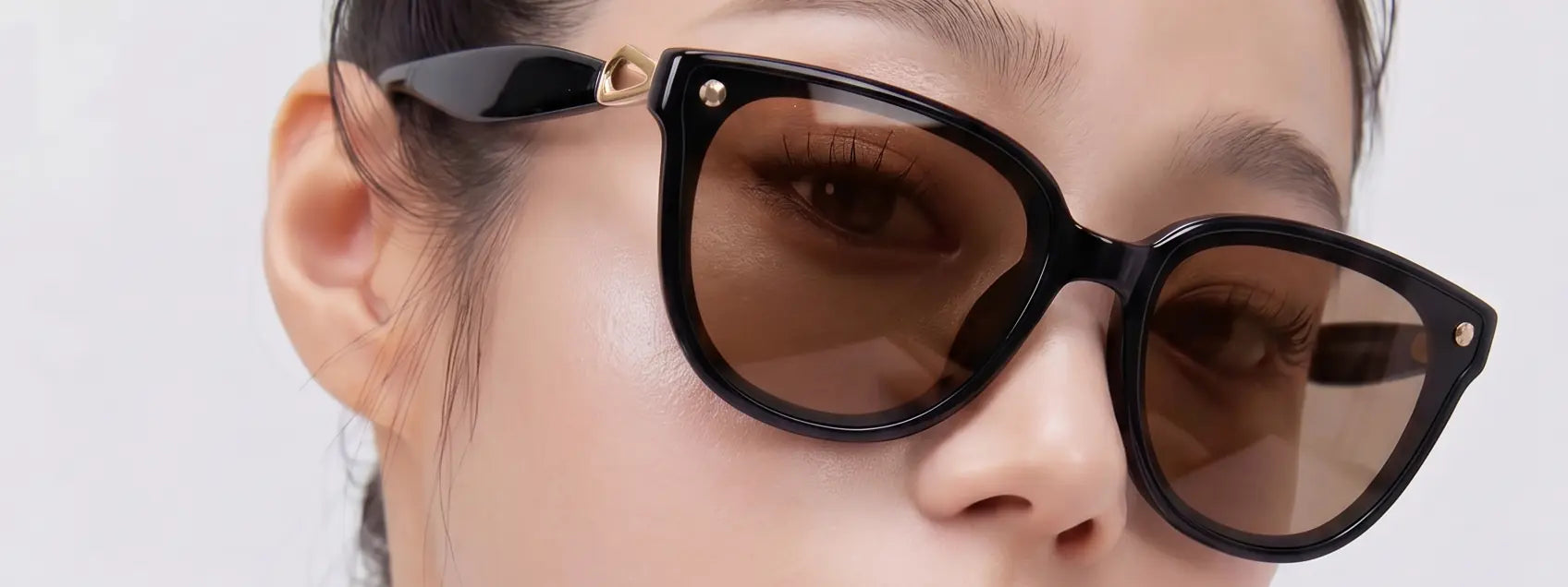 Close-up of Sweet Pain NANA C1 sunglasses in glossy black with citrus lens, editorial campaign slide